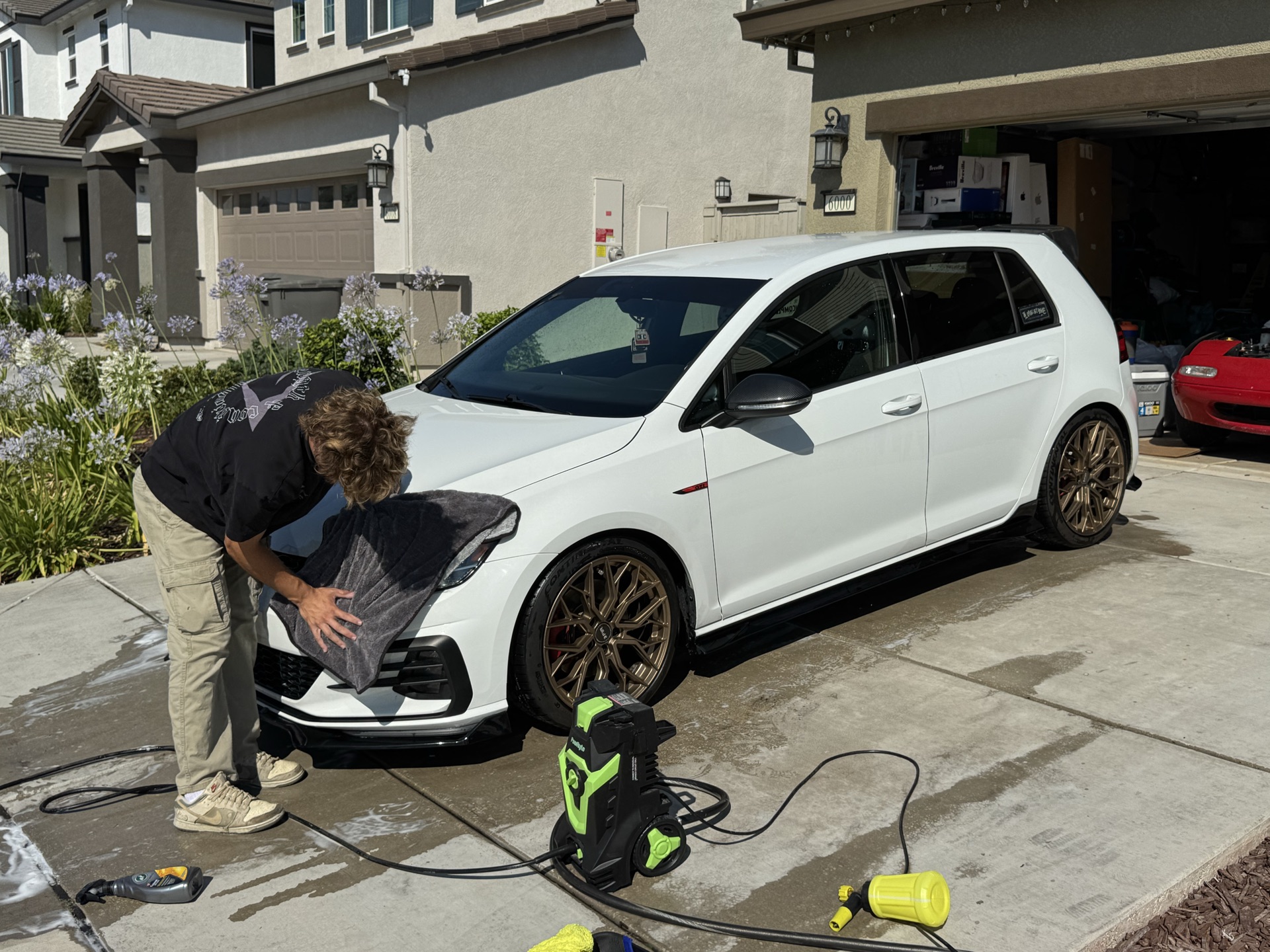 Freshly detailed white Volkswagen GTI gleaming in a Sacramento-area driveway