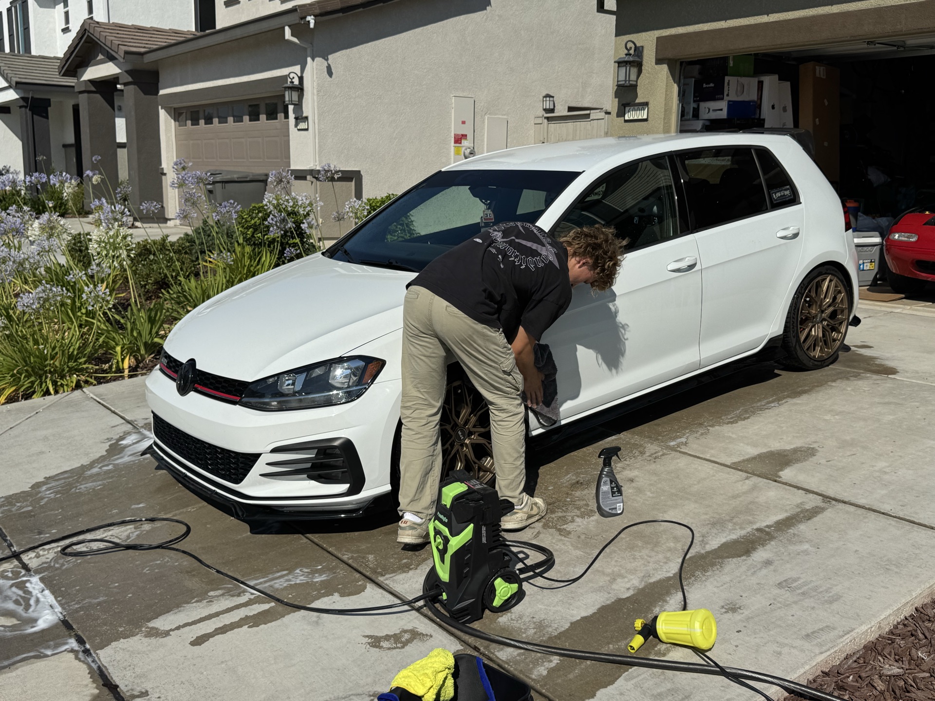 Exclusive Detailing crew detailing a white GTI in a Sacramento-area driveway